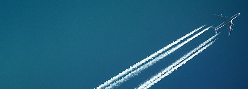 Plane flying through sky leaving trails